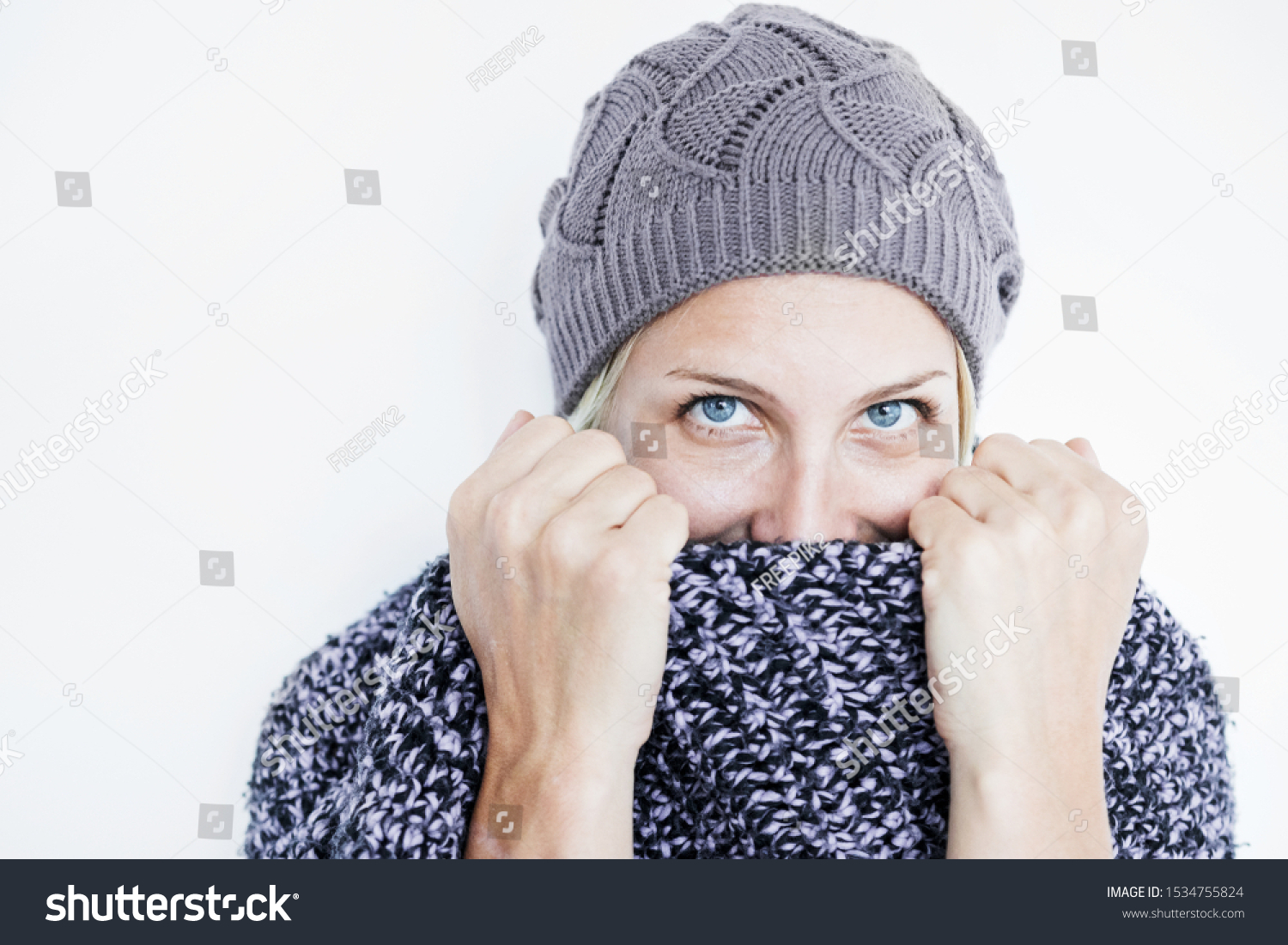 Pretty woman hiding face behind scarf #1534755824