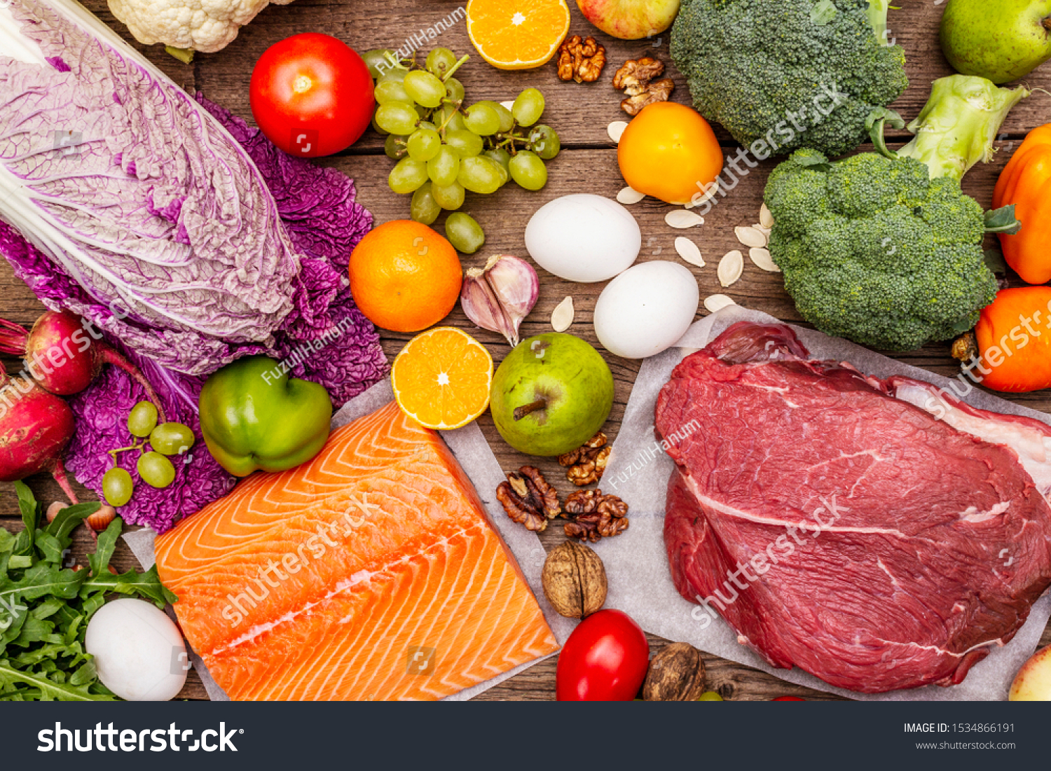 Trending paleo/pegan diet. Healthy balanced food concept. Set of fresh products, raw meat, salmon, vegetables and fruits. Old wooden boards background, top view #1534866191