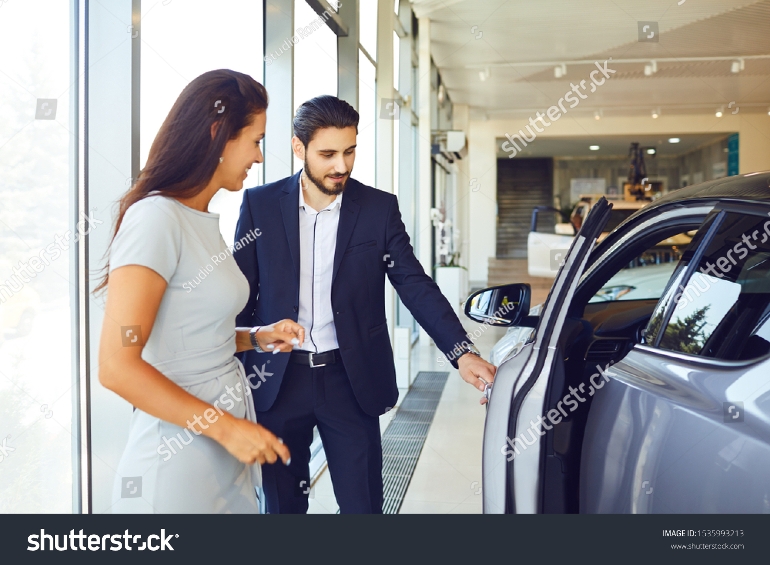A young woman buys a new car in an auto salon #1535993213