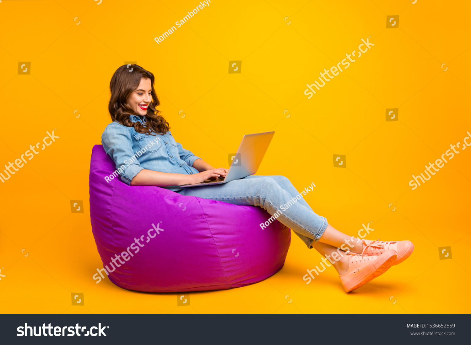 Full length body size turned photo of cheerful positive cute nice attractive blogger browsing through her laptop in search of new information isolated over yellow vibrant color background #1536652559
