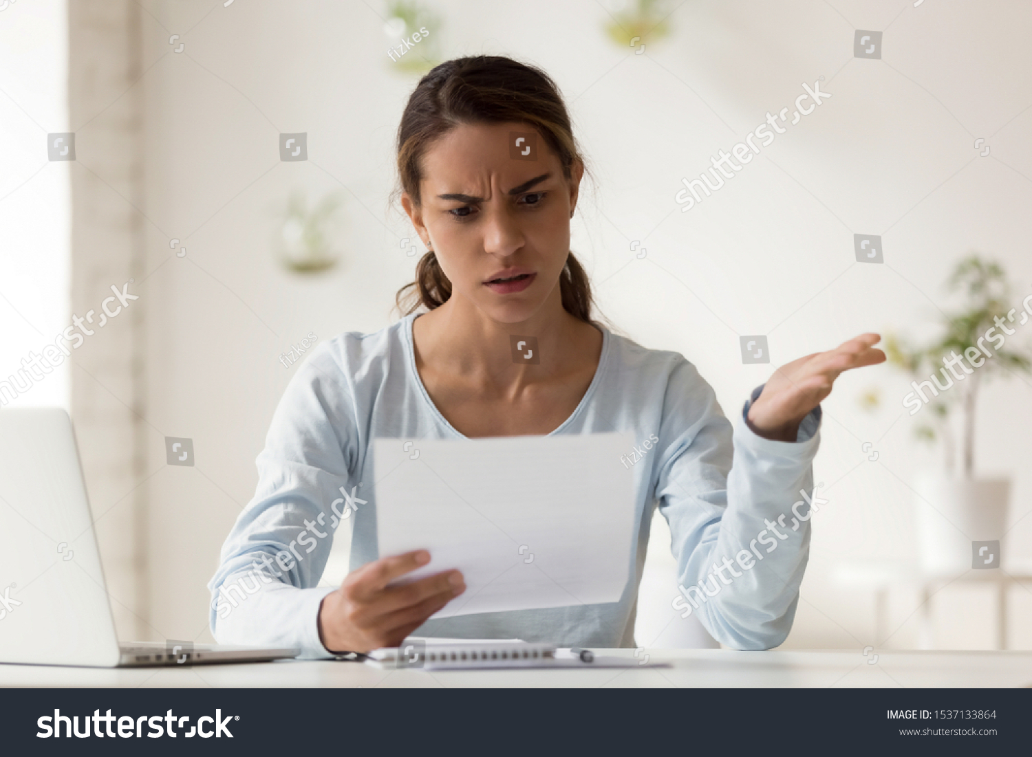Head shot portrait stressed millennial mixed race woman reading paper with bad news. Frowning female employee irritated by dismissal notice. Unhappy young lady disagree with false information. #1537133864