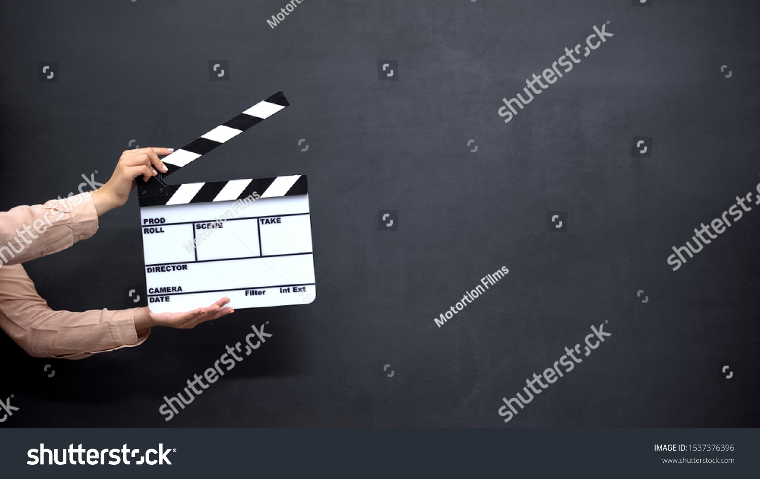 Female hands using clapperboard against black background, shooting movies #1537376396