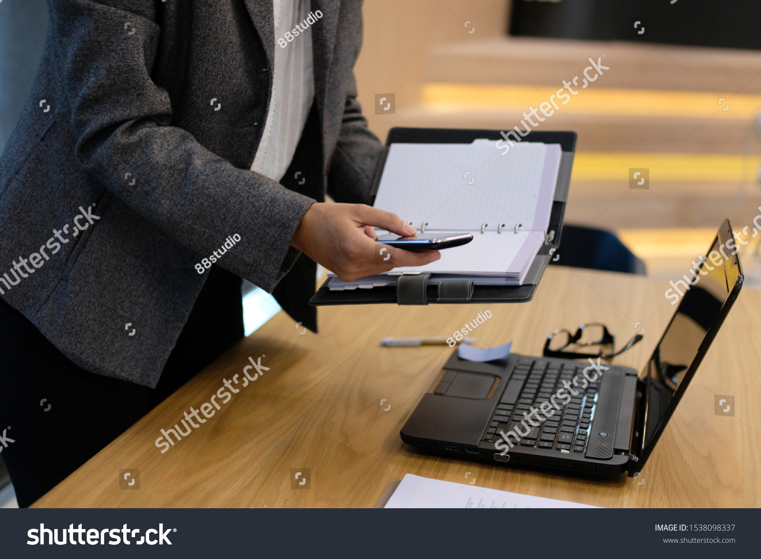 woman with notebook & smart phone working organizing plan at workplace office #1538098337