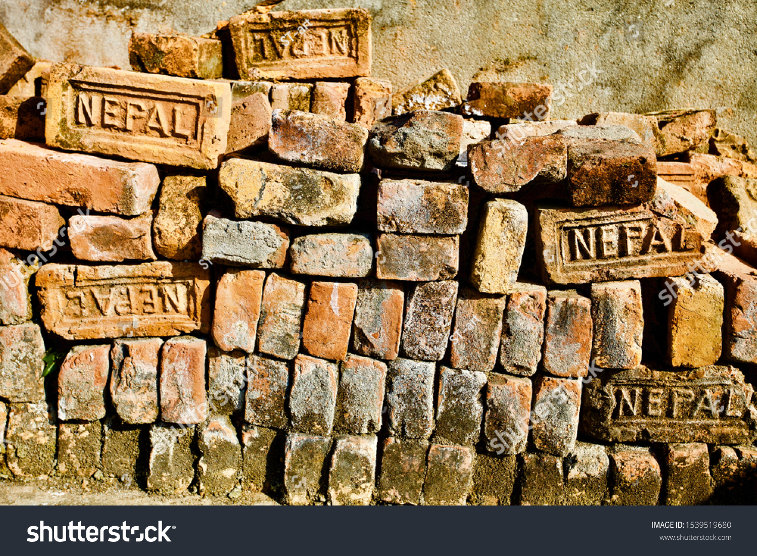 Bricks pile close up view. Old Bricks Texture. Orange and Yellow antique Bricks pattern. Construction industry raw materials. Building materials. Vintage Bricks pile from Nepal. Abstract backgrounds. #1539519680