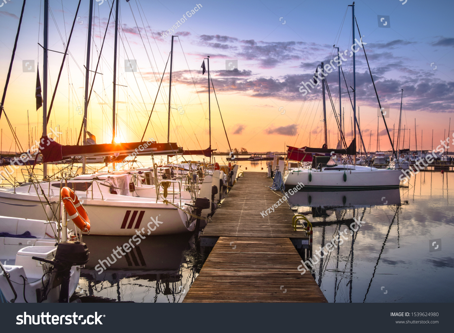Boats moored in the marina at Lake Niegocin during sunrise. Wilkasy, Masuria, Poland. #1539624980