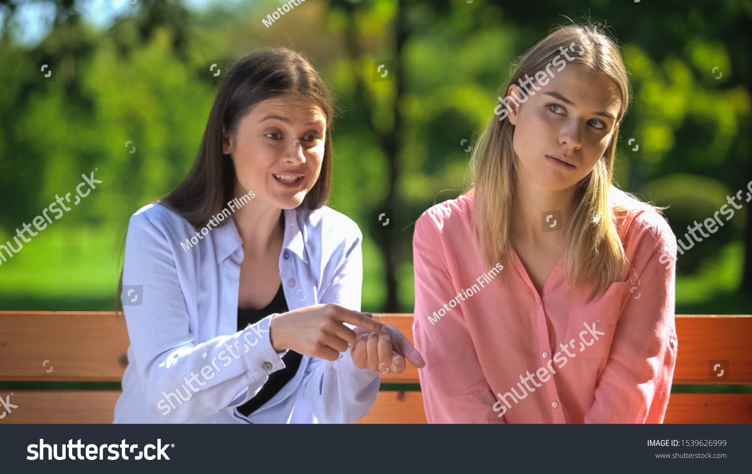 Tired female listening to annoying friend sitting outdoors, envy, selfishness #1539626999