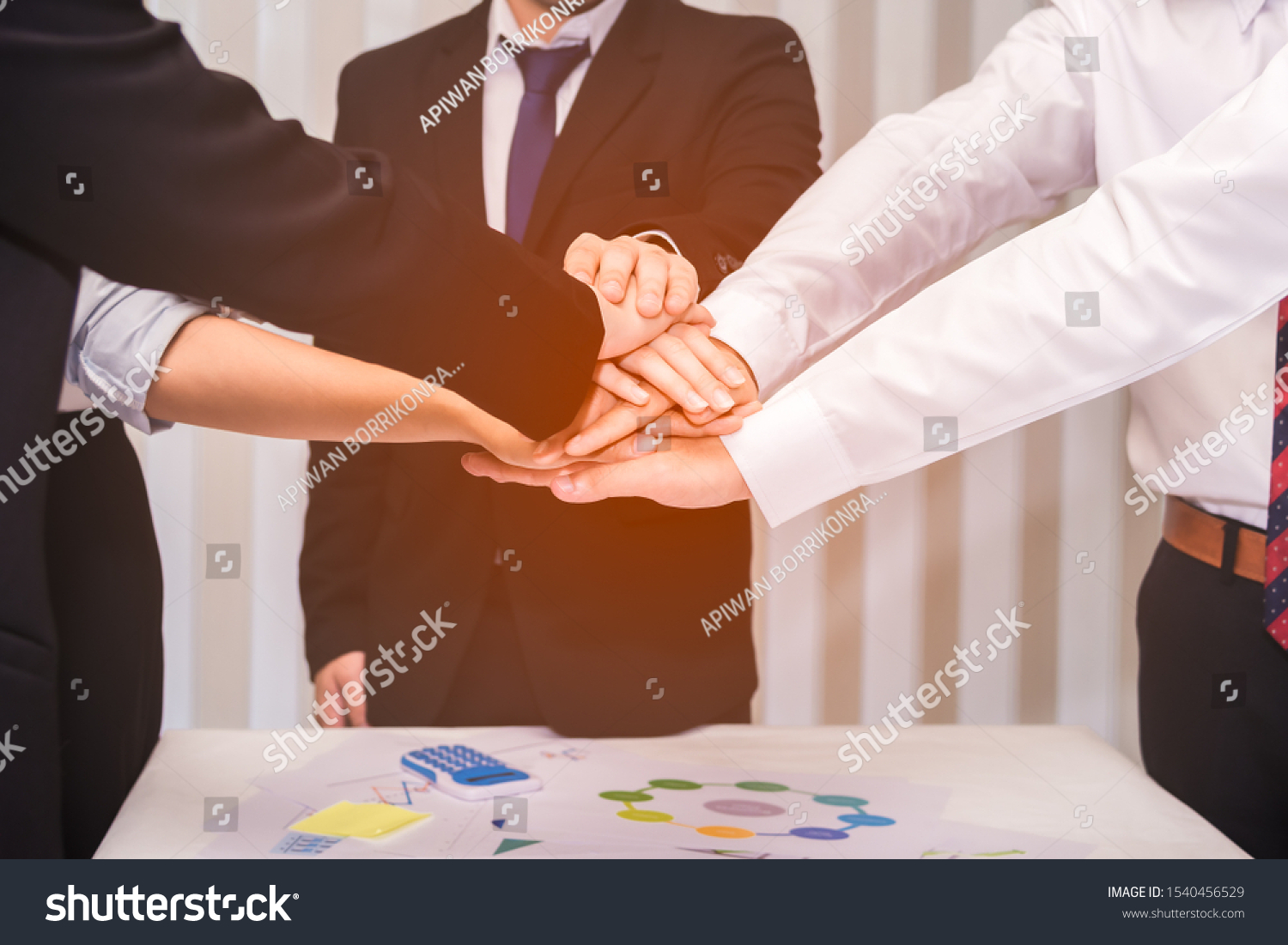 Group of businesspeople putting stacking hands while meeting for showing unity of teamwork. Business and teamwork concept. #1540456529
