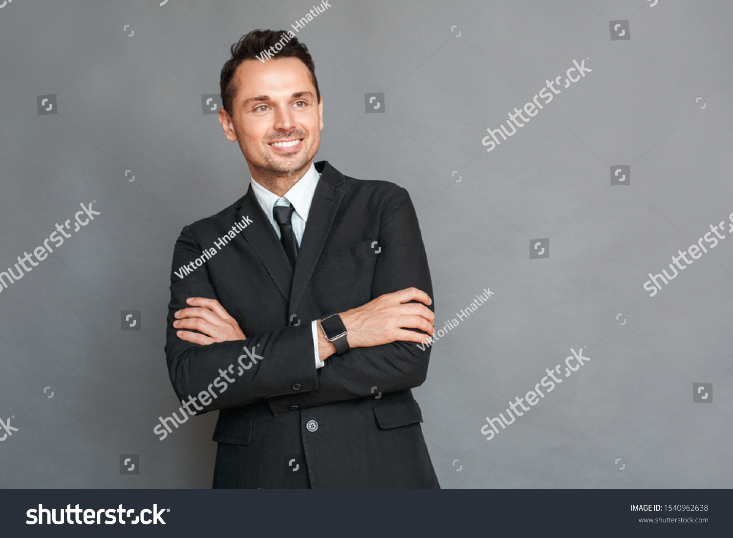 Business man studio standing isolated on grey wall crossed arms looking aside smiling cheerful #1540962638