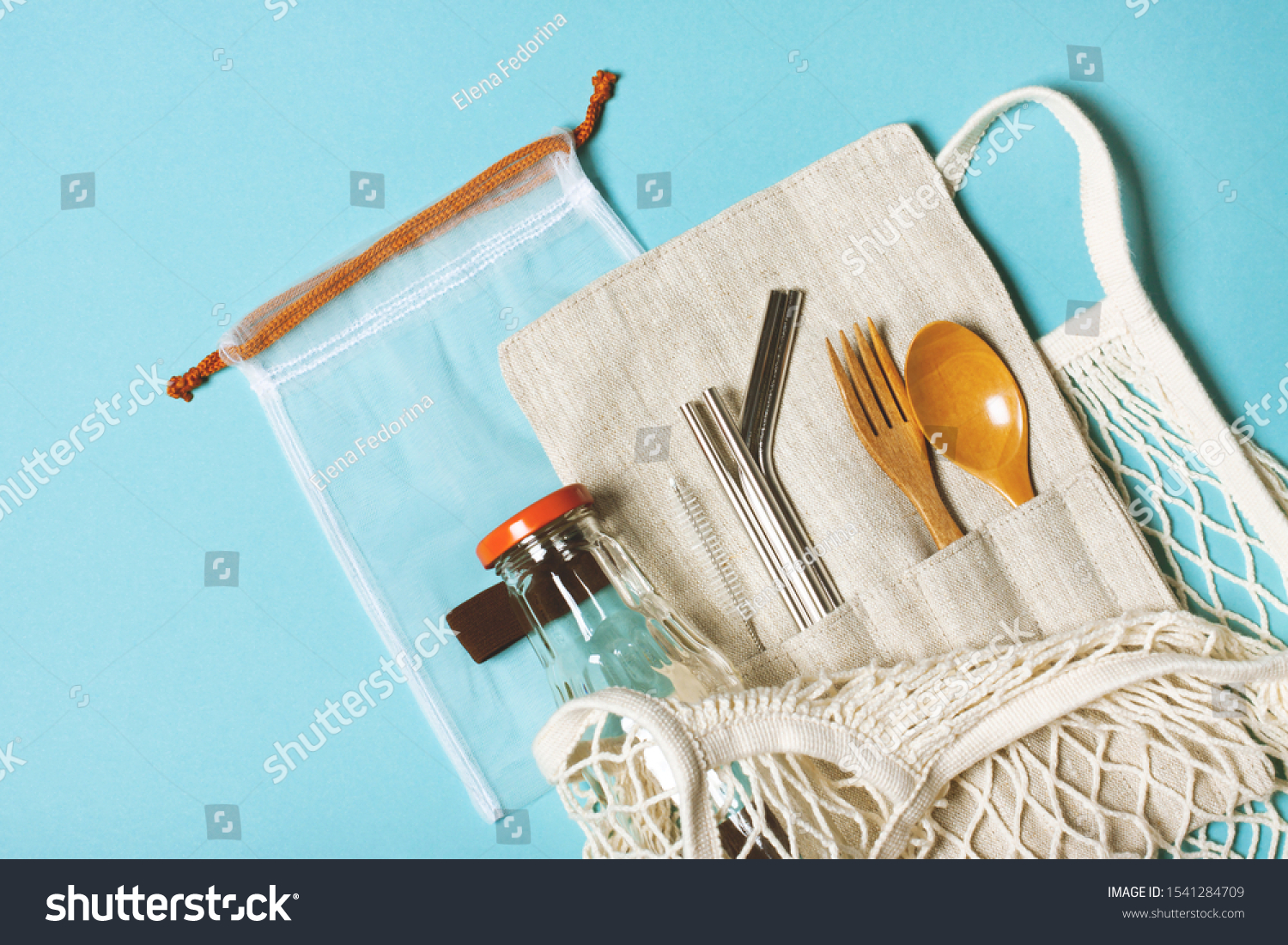 Set of reusable items for an eco-friendly lifestyle. Eco bag, glass bottle for water, metal tubes, wooden fork and spoon. Zero waste concept, plastic-free, organic, eco-friendly shopping #1541284709