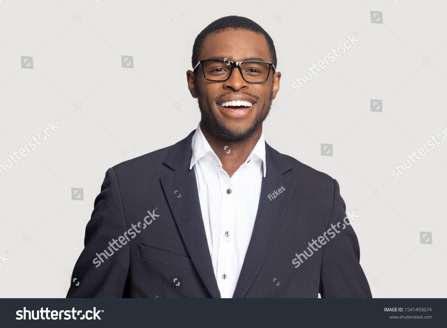 Head shot portrait close up smiling successful African American businessman looking at camera, laughing, excited man wearing formal suit and glasses isolated on grey studio background #1541493674