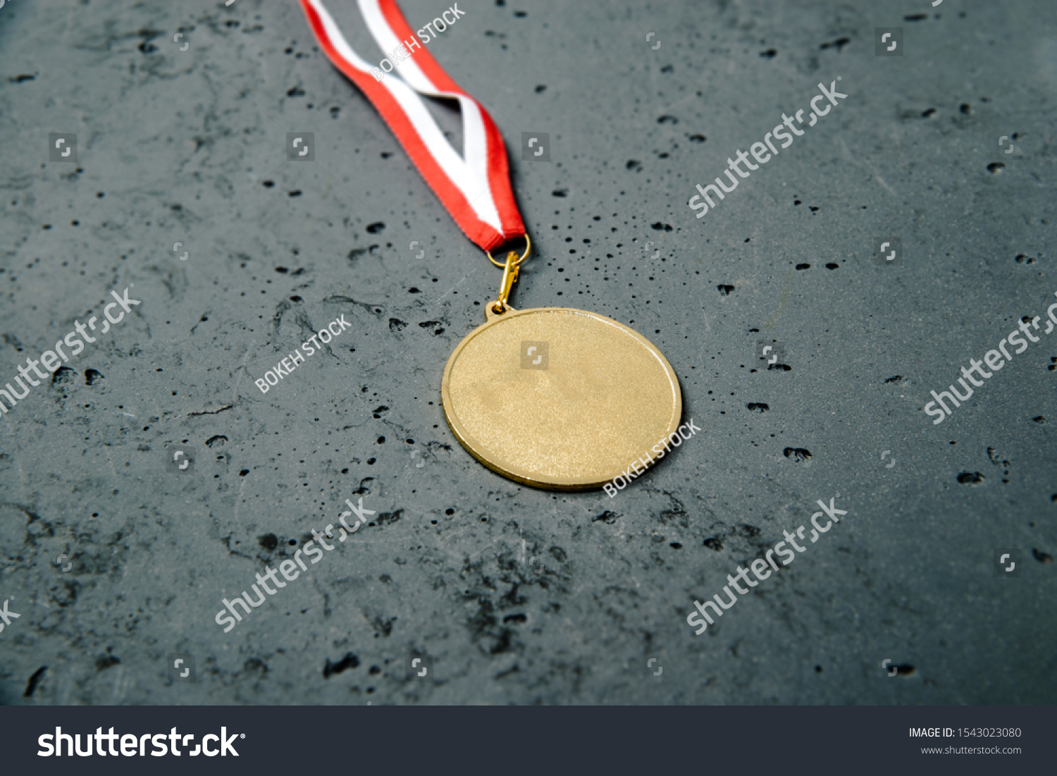 Gold Medal lie on a stone background. Gold medal on a dark background. The concept of tournaments and competitions. Victory, winning competitions. #1543023080