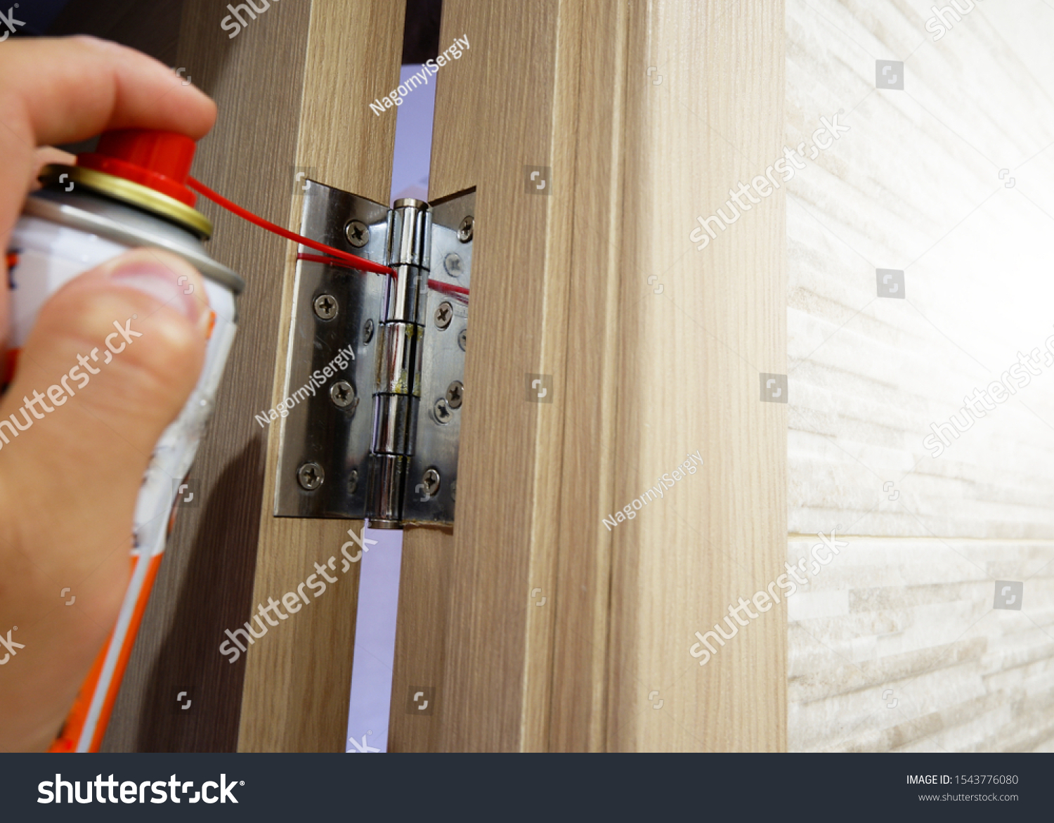 A man lubricates door hinges with oil. #1543776080