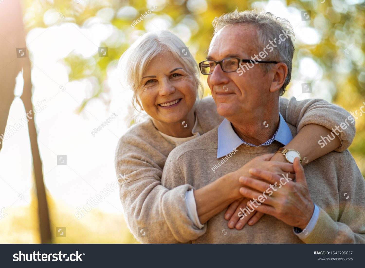 Elderly couple embracing in autumn park 
 #1543795637