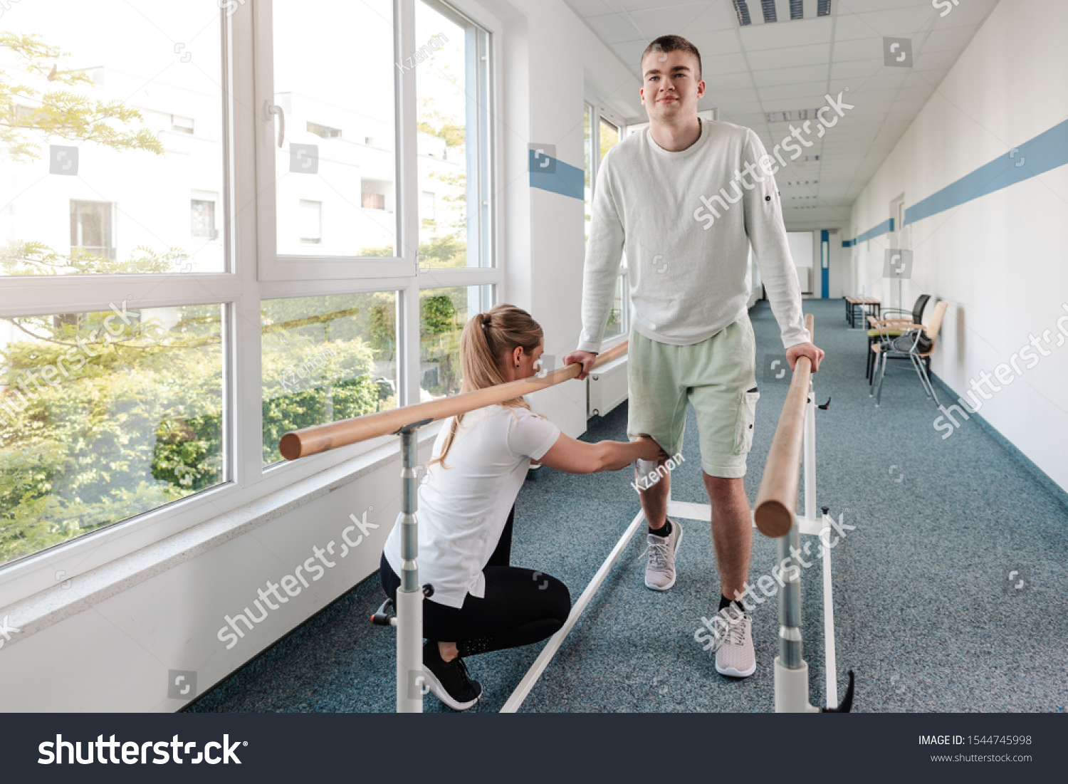 Young man in walking rehabilitation course after a sport injury on his knee #1544745998