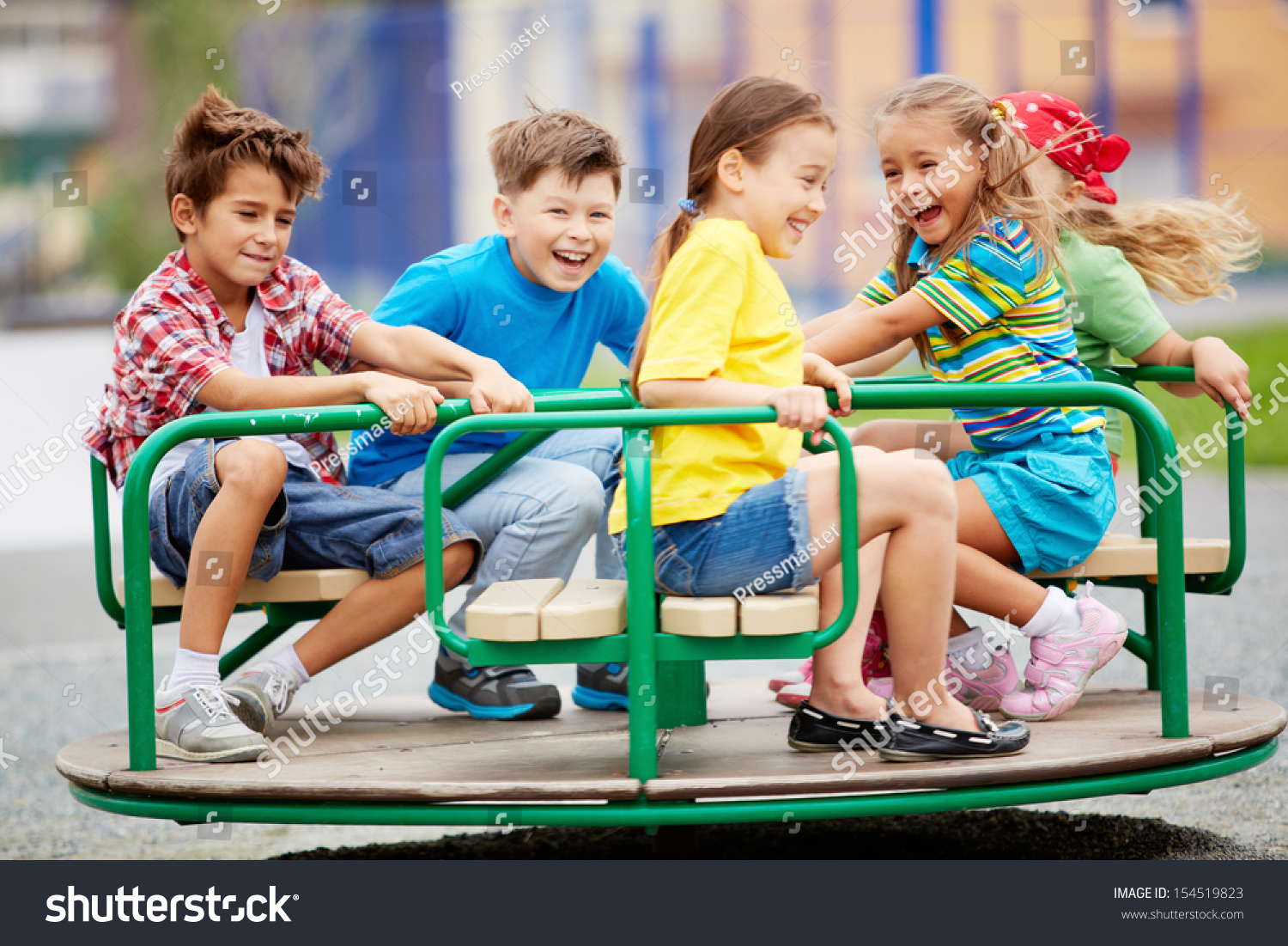 Image of joyful friends having fun on carousel outdoors  #154519823