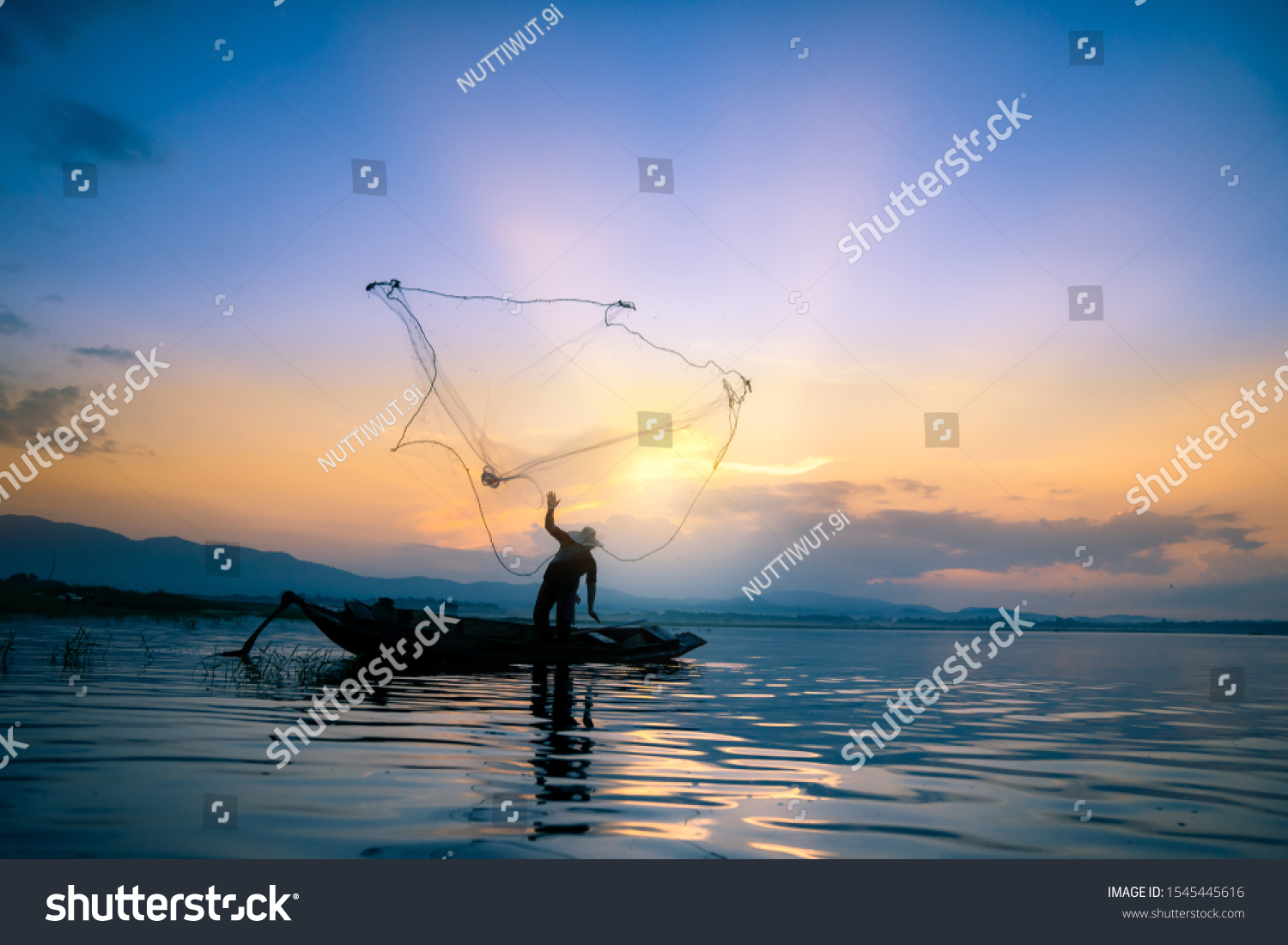 Lifestyle of Asian fisherman on wooden boat for catching freshwater fish in reservoir in the early morning before sunrise #1545445616