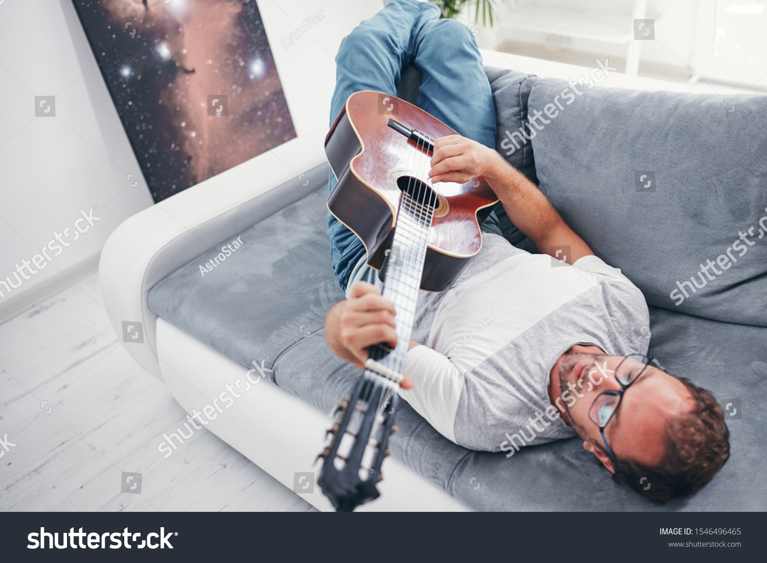 Man playing acoustic guitar in the living room. #1546496465
