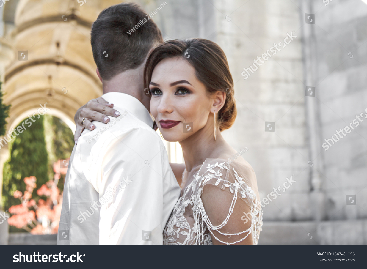 Portreit of wedding couple hugging on the romantic old city. Bride wearing elegant wedding dress  #1547481056