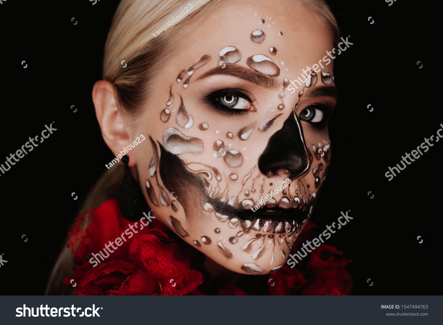 Portrait of a woman with sugar skull makeup over red background. Halloween costume and make-up.  #1547494763
