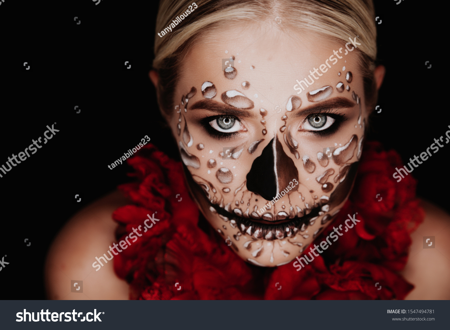 Portrait of a woman with sugar skull makeup over red background. Halloween costume and make-up.  #1547494781