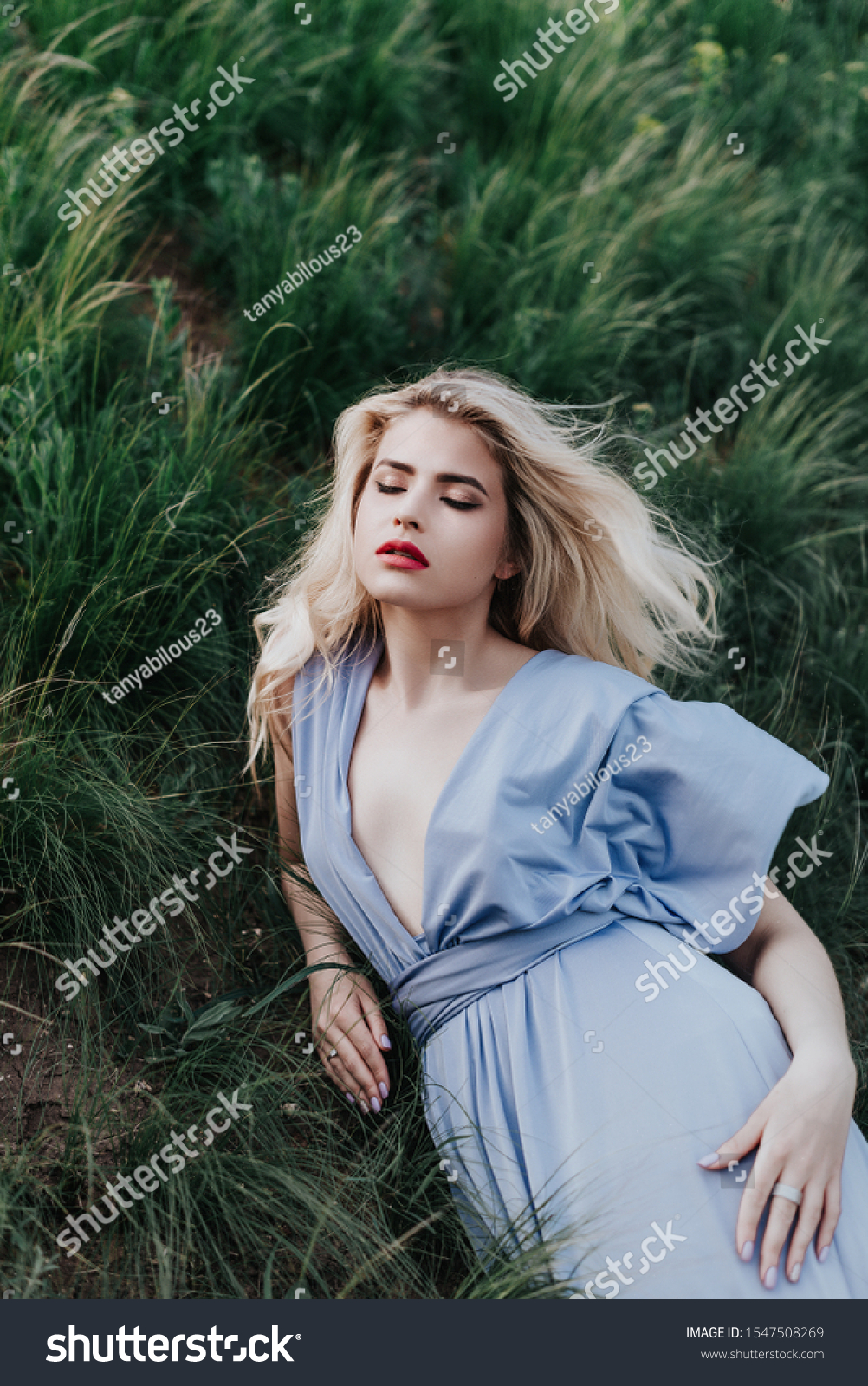 young girl dressed in an elegant long lilac dress. A neat hairstyle of blond hair, blonde, walks across the field in the forest. Happy escaped the mysterious princess. #1547508269