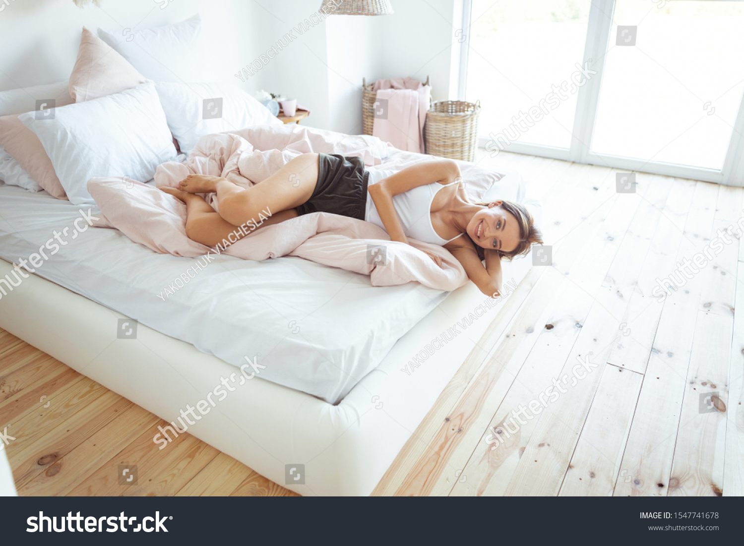 Tender bedclothes. Cute girl keeping smile on her face while spending morning in her bedroom #1547741678