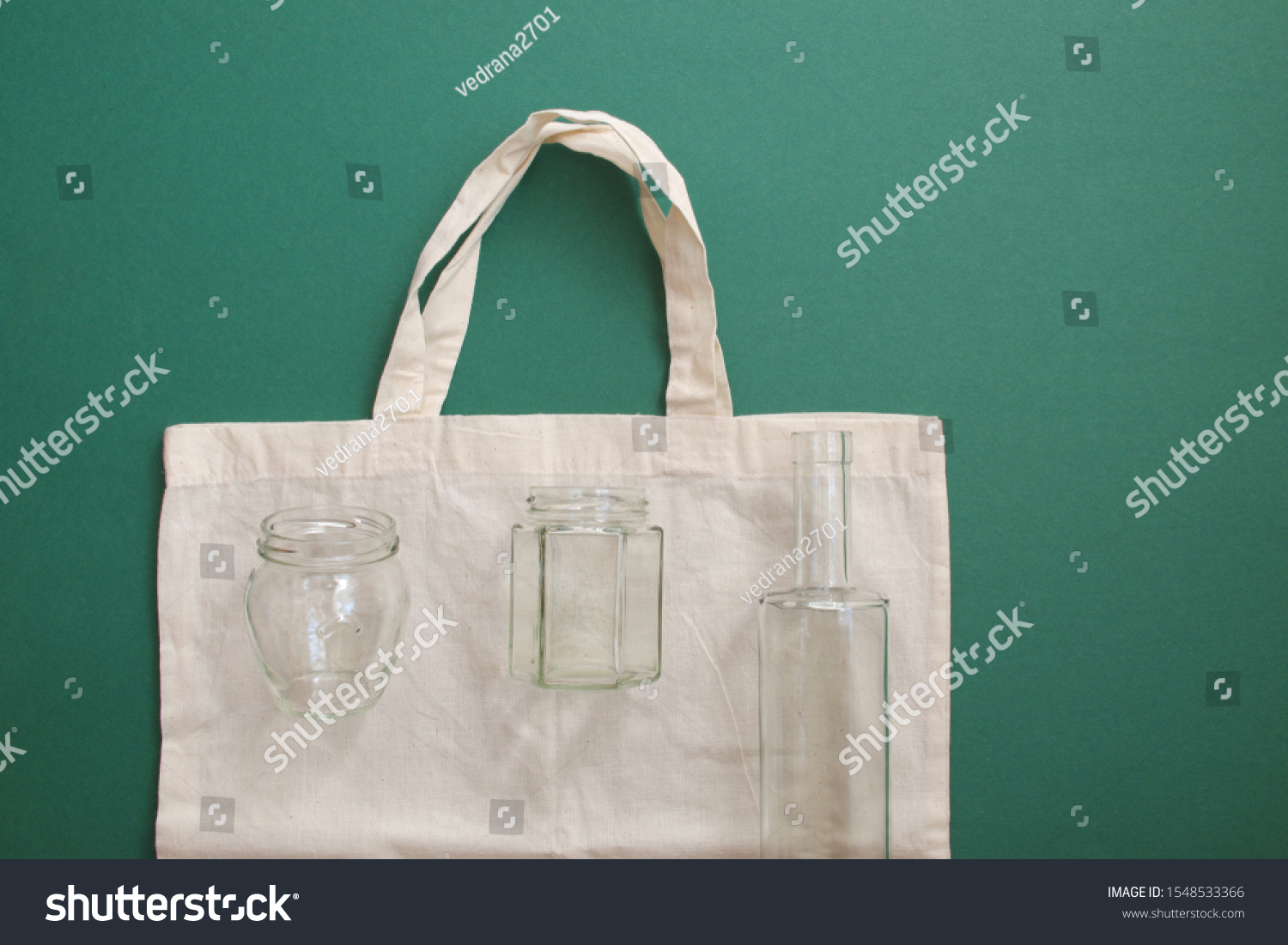 Reusable shopping bag and reusable glass bottles against the green background #1548533366
