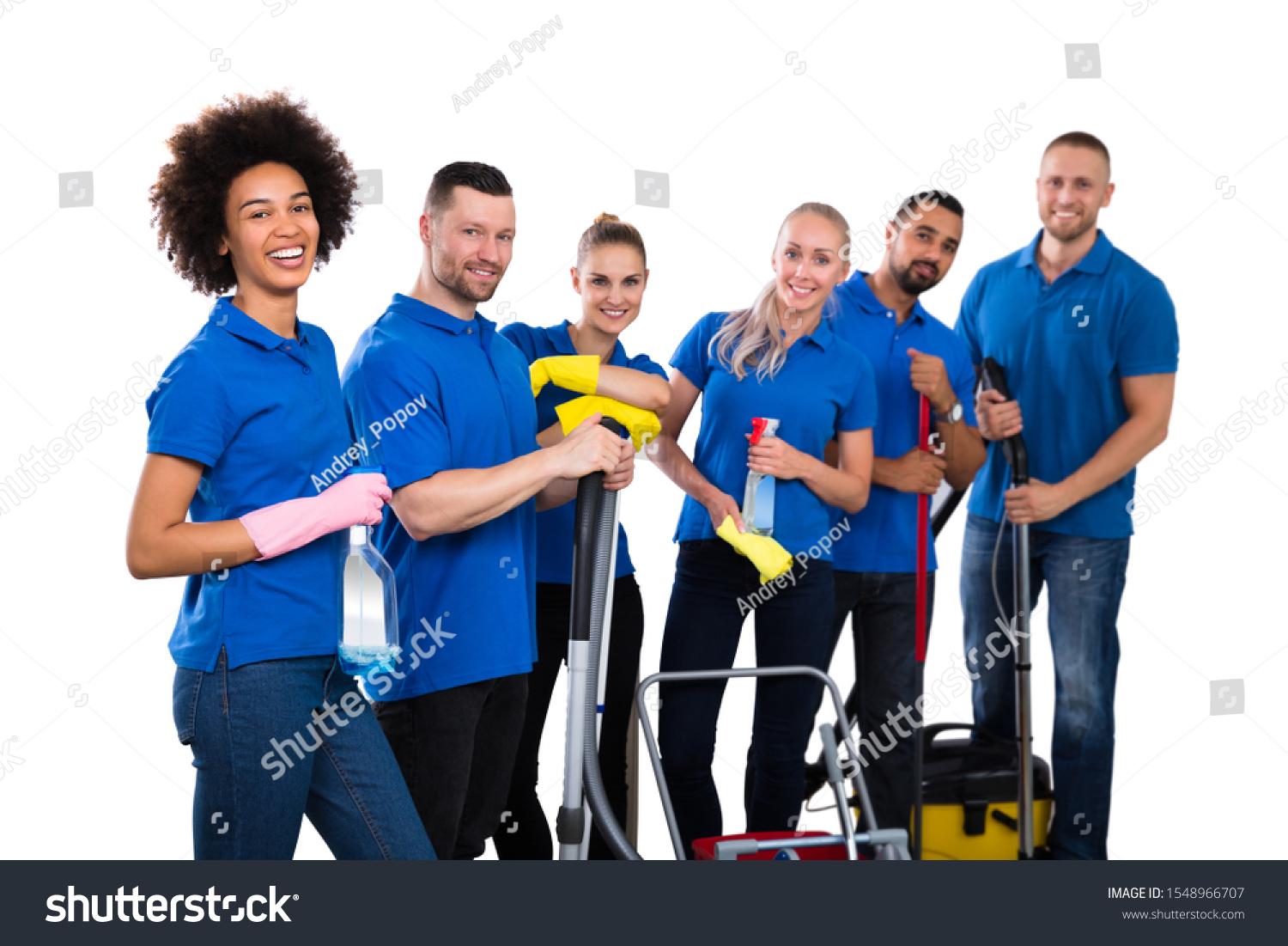 Smiling Multiethnic Group Of Janitors Wearing Blue T-shirt Standing Grouped Together With Their Equipment #1548966707