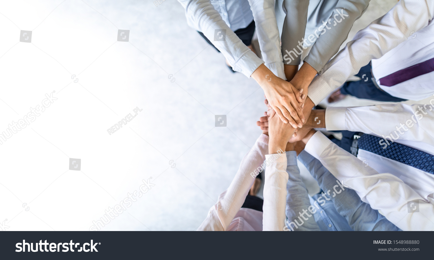 Close up top view of young business people putting their hands together. Stack of hands. Unity and teamwork concept. #1548988880