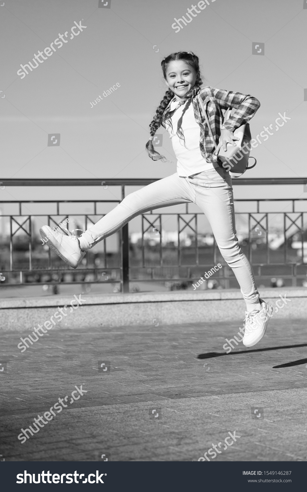 Being active outside. Active little child in motion on urban background. Happy small girl jumping active for pleasure. Active and energetic kid having fun in summer. #1549146287