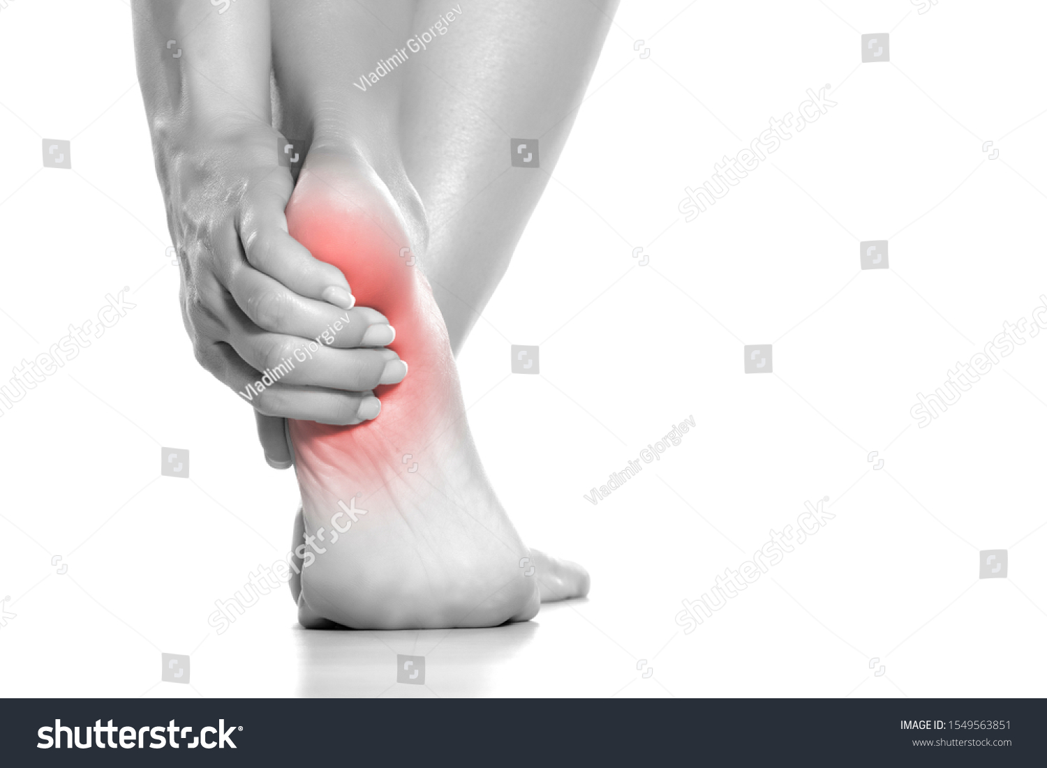 woman holding her painful heel on white background #1549563851