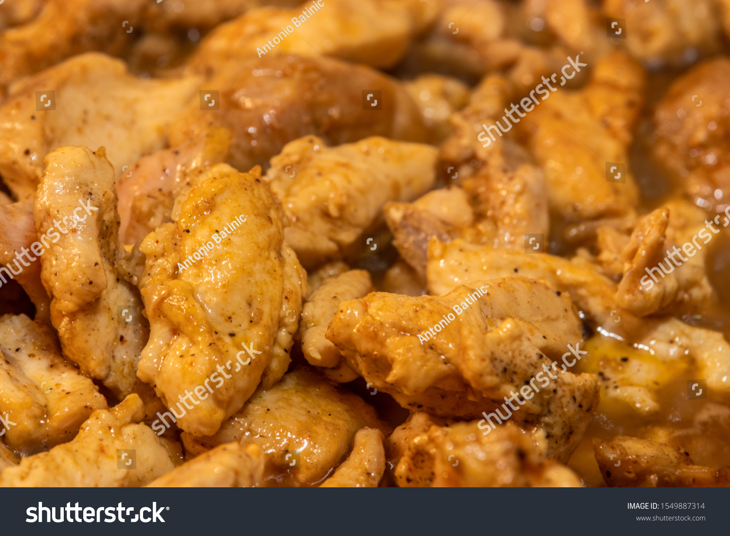 Marinated torn cut chicken bits being cooked, halfway cooked #1549887314