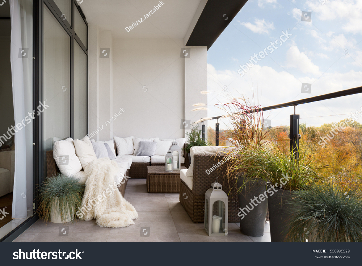 Elegant decorated balcony with rattan outdoor furniture, bright pillows and plants #1550995529
