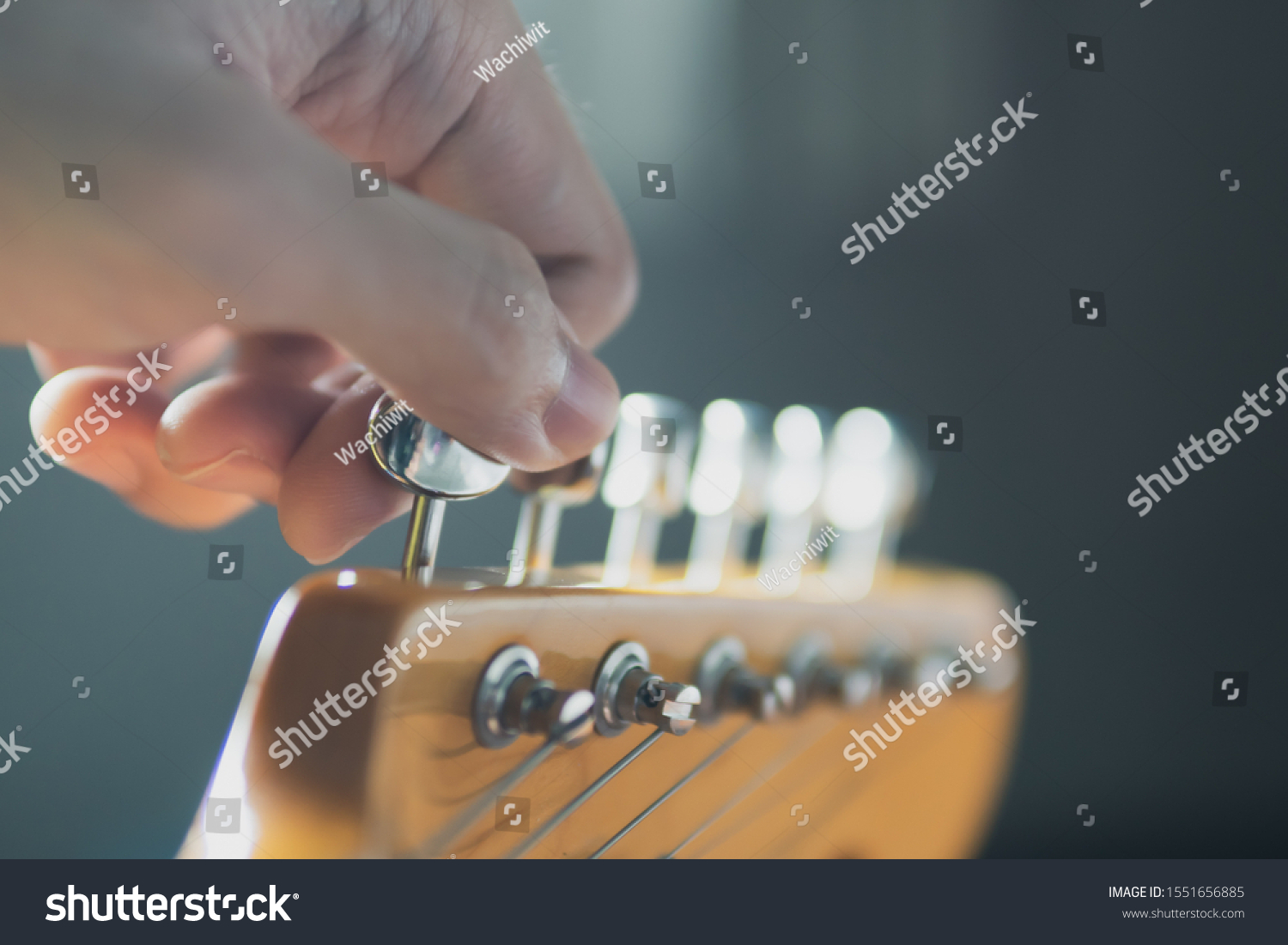 Tuning guitar string by adjusting tuning machines #1551656885