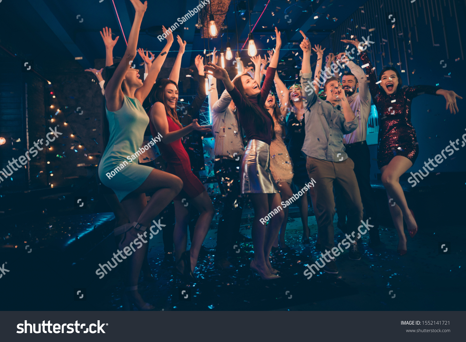 Full length body size photo of company dancing cheerfully at night club under falling confetti and light of shining lamps with smiles on their faces #1552141721