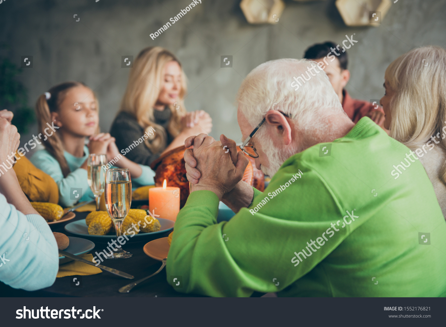Big family small little kids mature retired people meeting on thanksgiving day sit table with large banquet meal roasted meat wine candles pray in house #1552176821