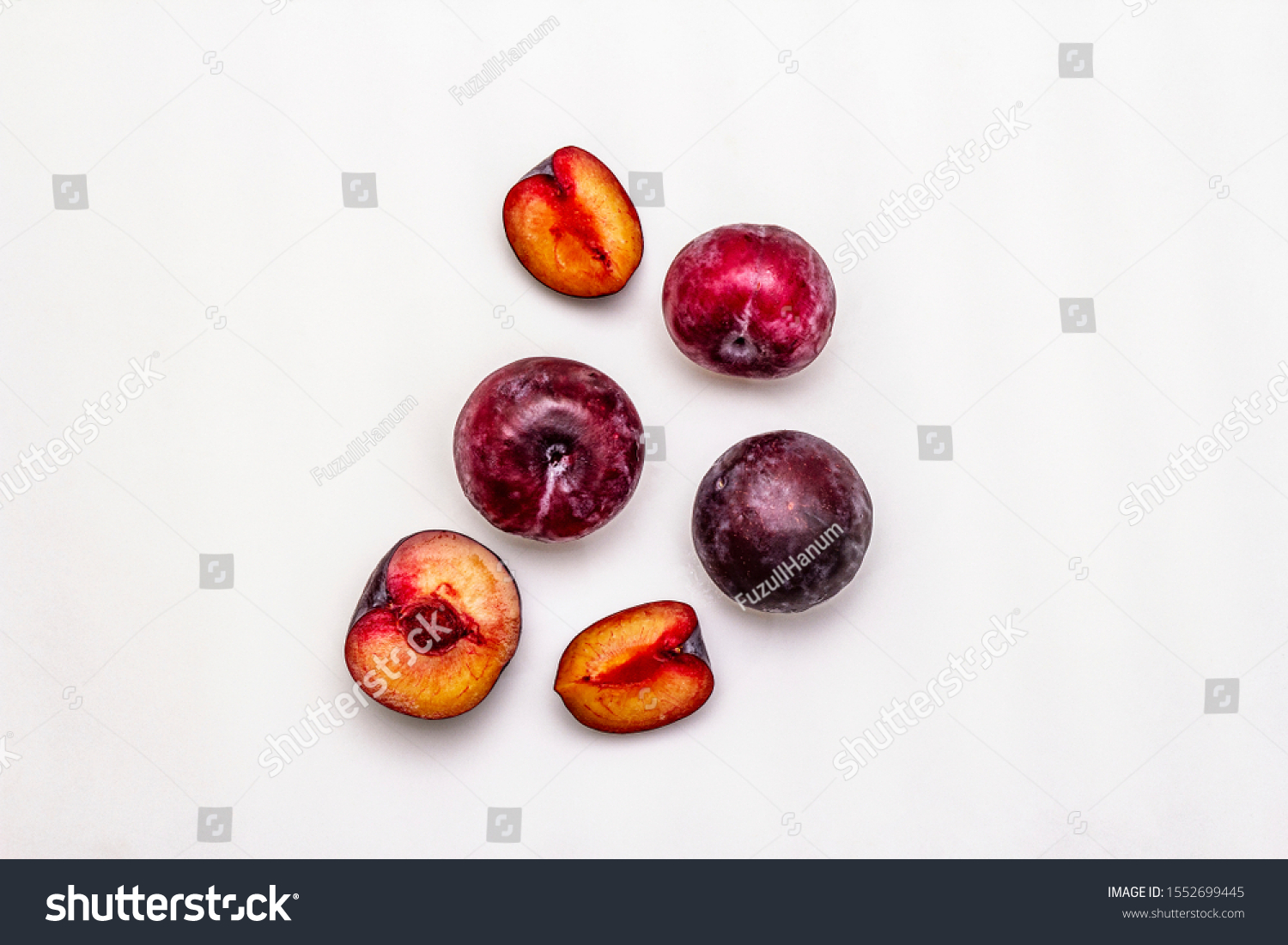 Ripe large purple plums. Fresh whole fruits, half sliced, seeds. Isolated on white background, copy space, top view #1552699445