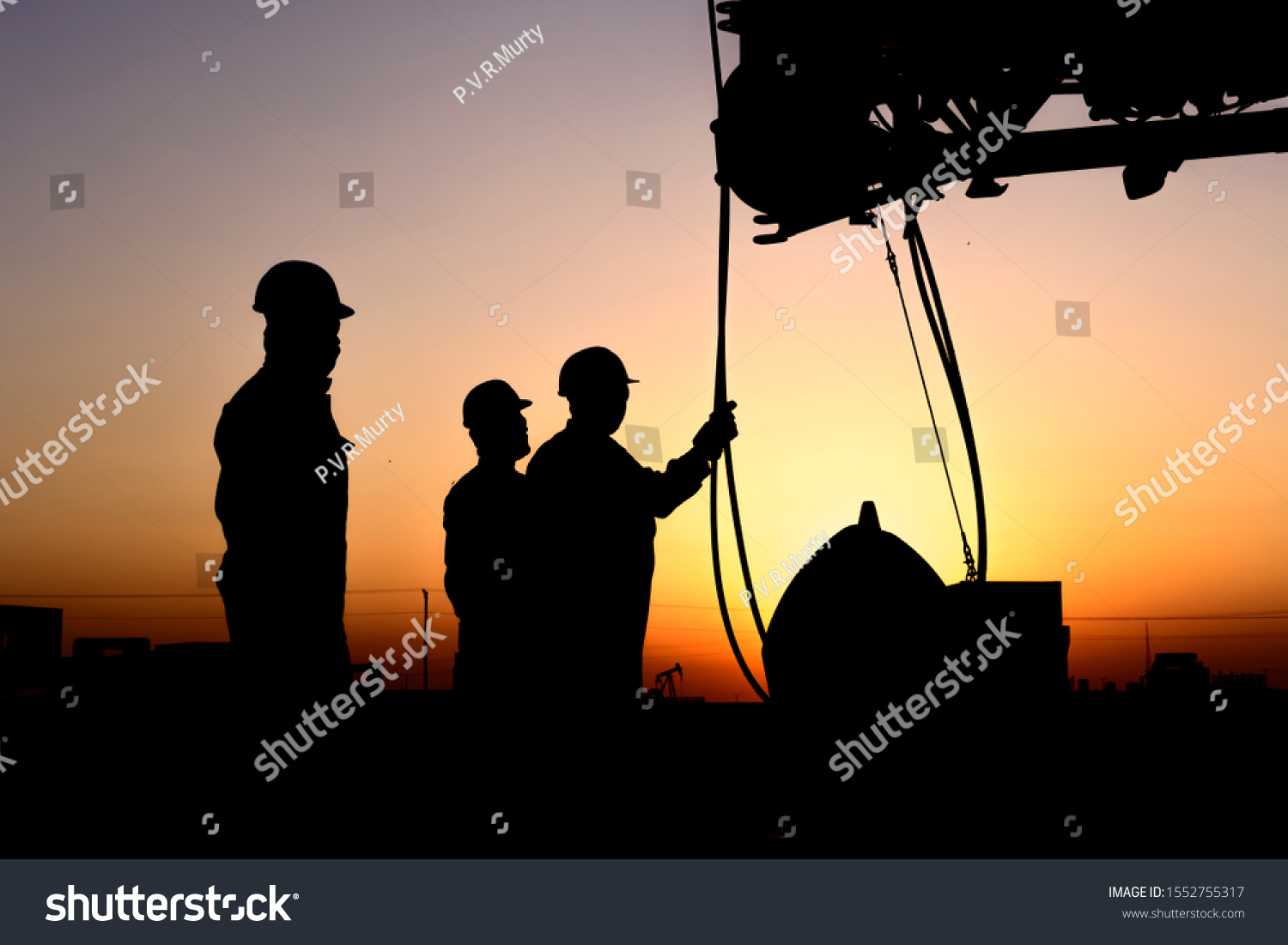 Silhouette of riggers working with mobile crane in the oilfield at sunset
 #1552755317