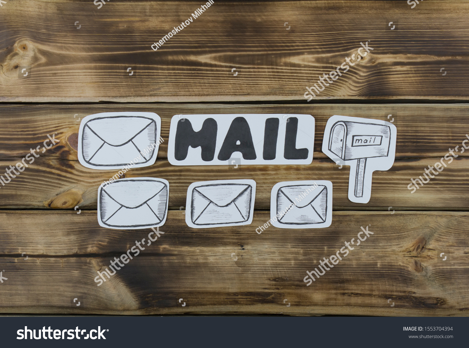 Paper sketched sketches with mail-themed letters on wooden #1553704394
