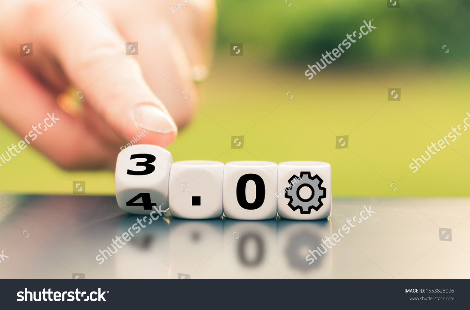 Hand is turning a dice and changes the expression "Industry 3.0" to "Industry 4.0"	 #1553828006
