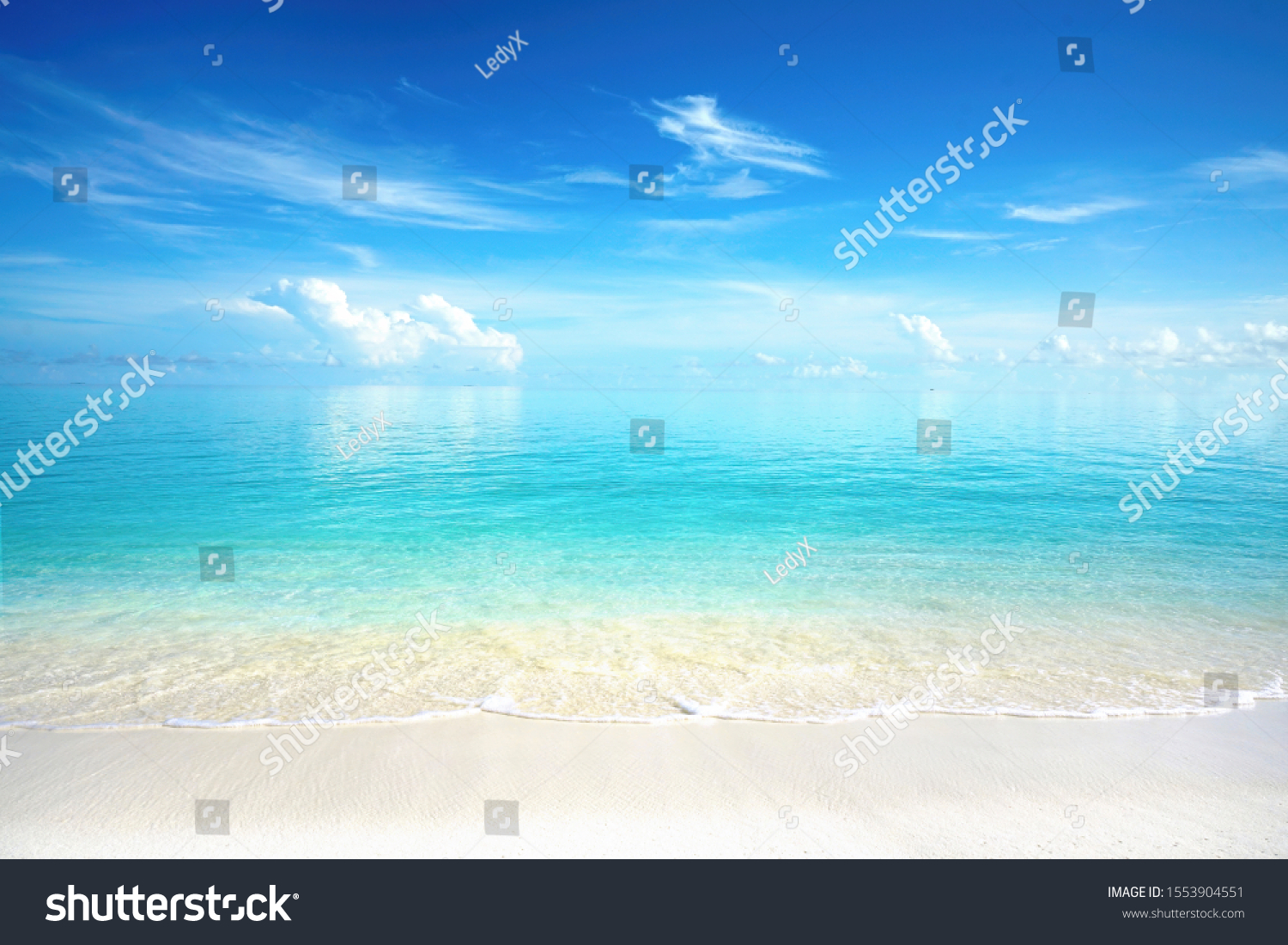 Beautiful sandy beach with white sand and rolling calm wave of turquoise ocean on Sunny day. White clouds in blue sky are reflected in water. Maldives, perfect scenery landscape, copy space. #1553904551