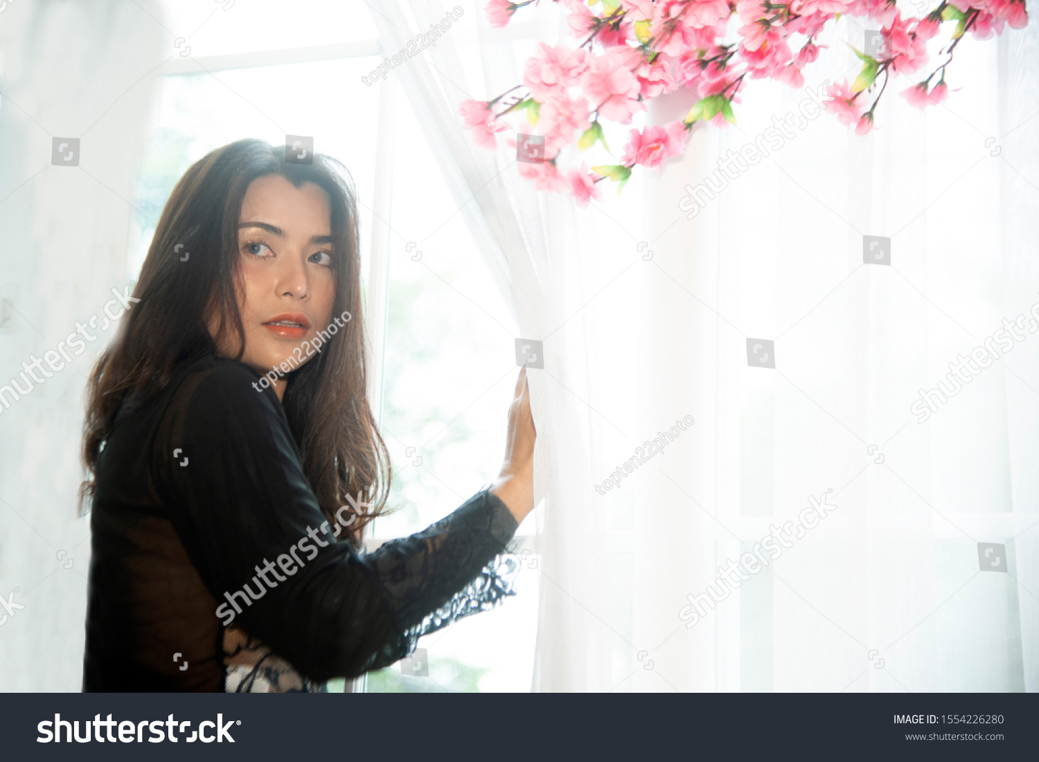Sensual sexy dresses Asian women sensuality standing under pink flower tree near window.   #1554226280