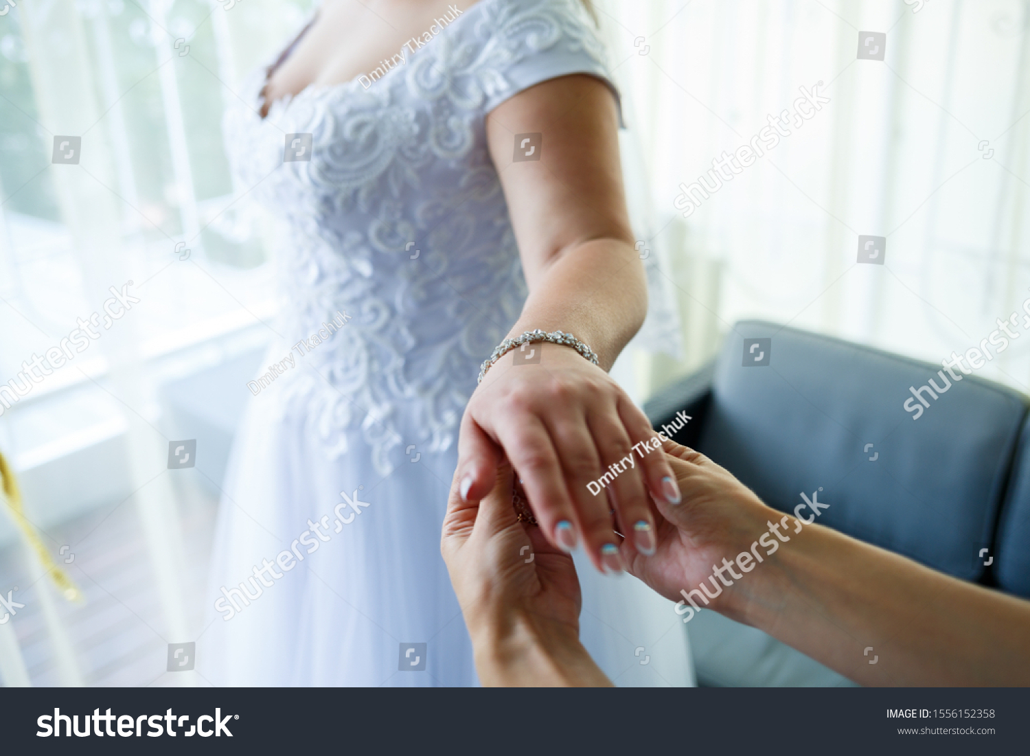 bride puts on wedding jewelry on the wedding day #1556152358