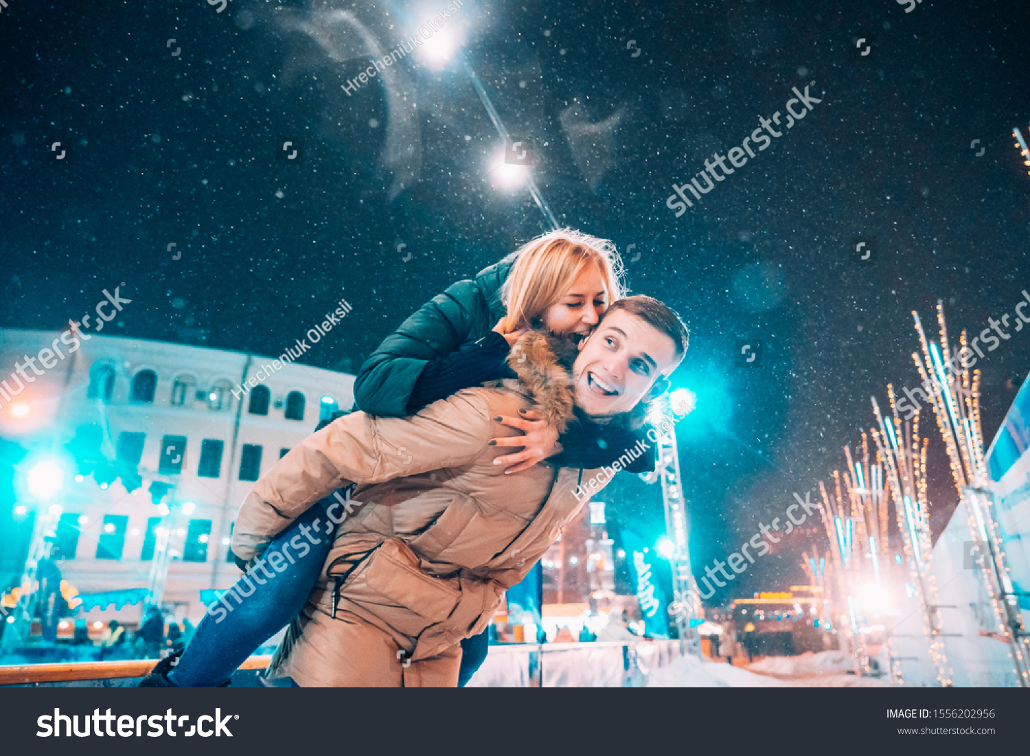 Cheerful and playful couple in warm winter outfits are fooling around #1556202956