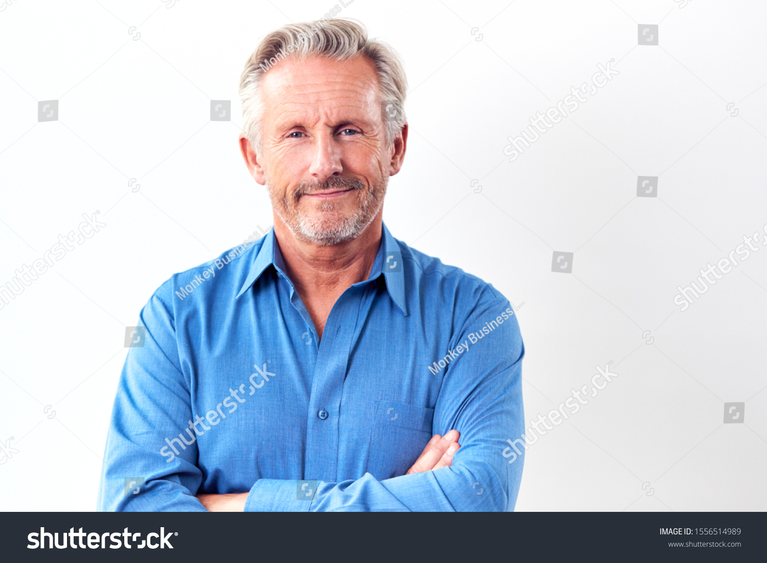 Studio Shot Of Mature Man Against White Background Smiling At Camera #1556514989