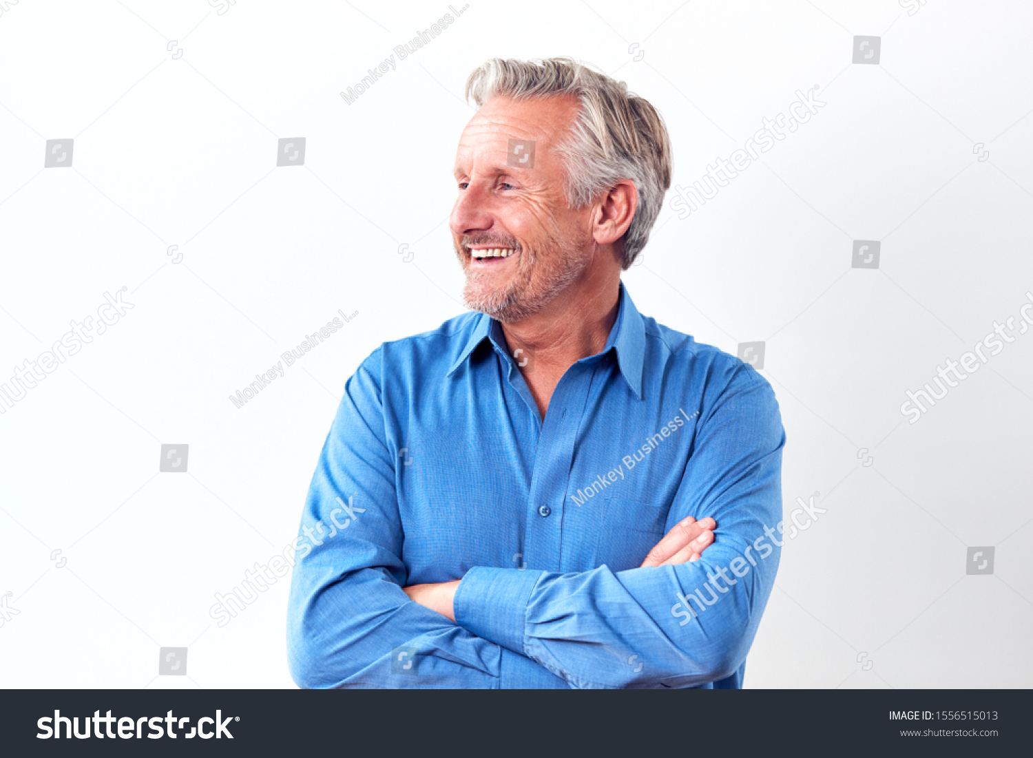 Studio Shot Of Mature Man Against White Background Laughing At Camera #1556515013