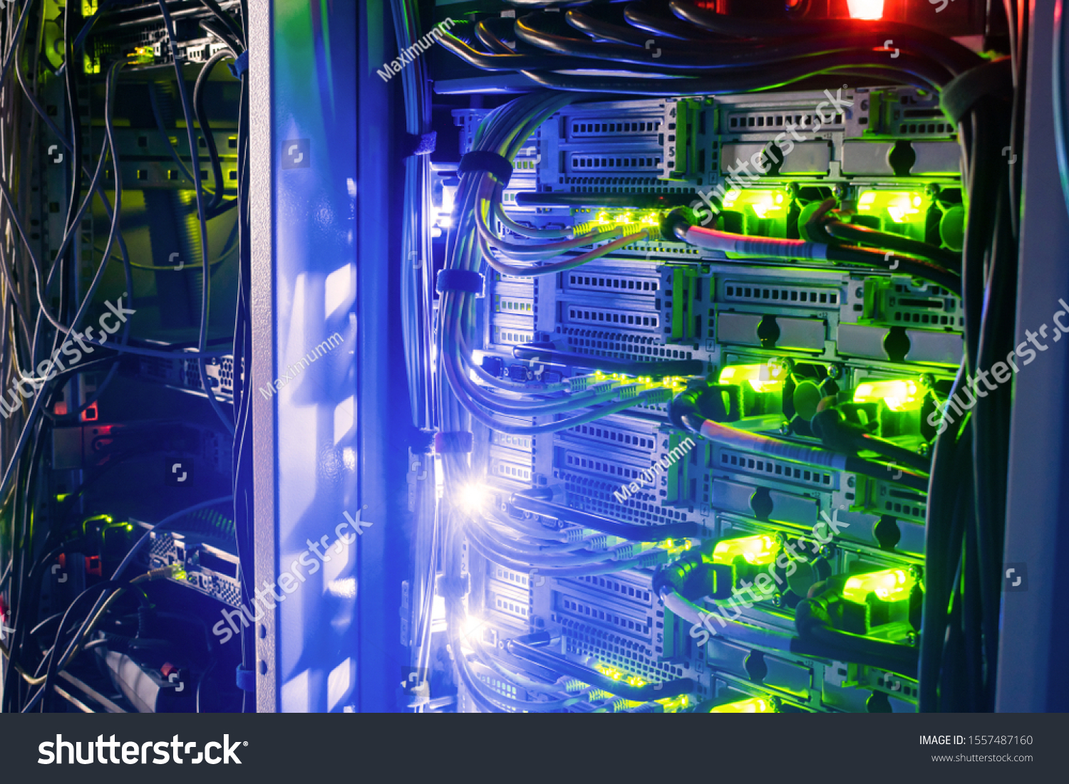Racks with server equipment are in the dark room of the data center. Colorful indication of the network interests of the Internet router. Information Technology Concept. #1557487160