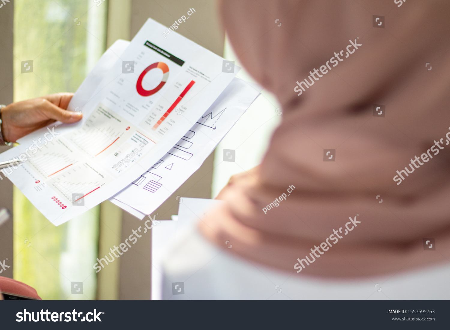 Close-up of a woman holding a document. Financial graph, pie graph #1557595763