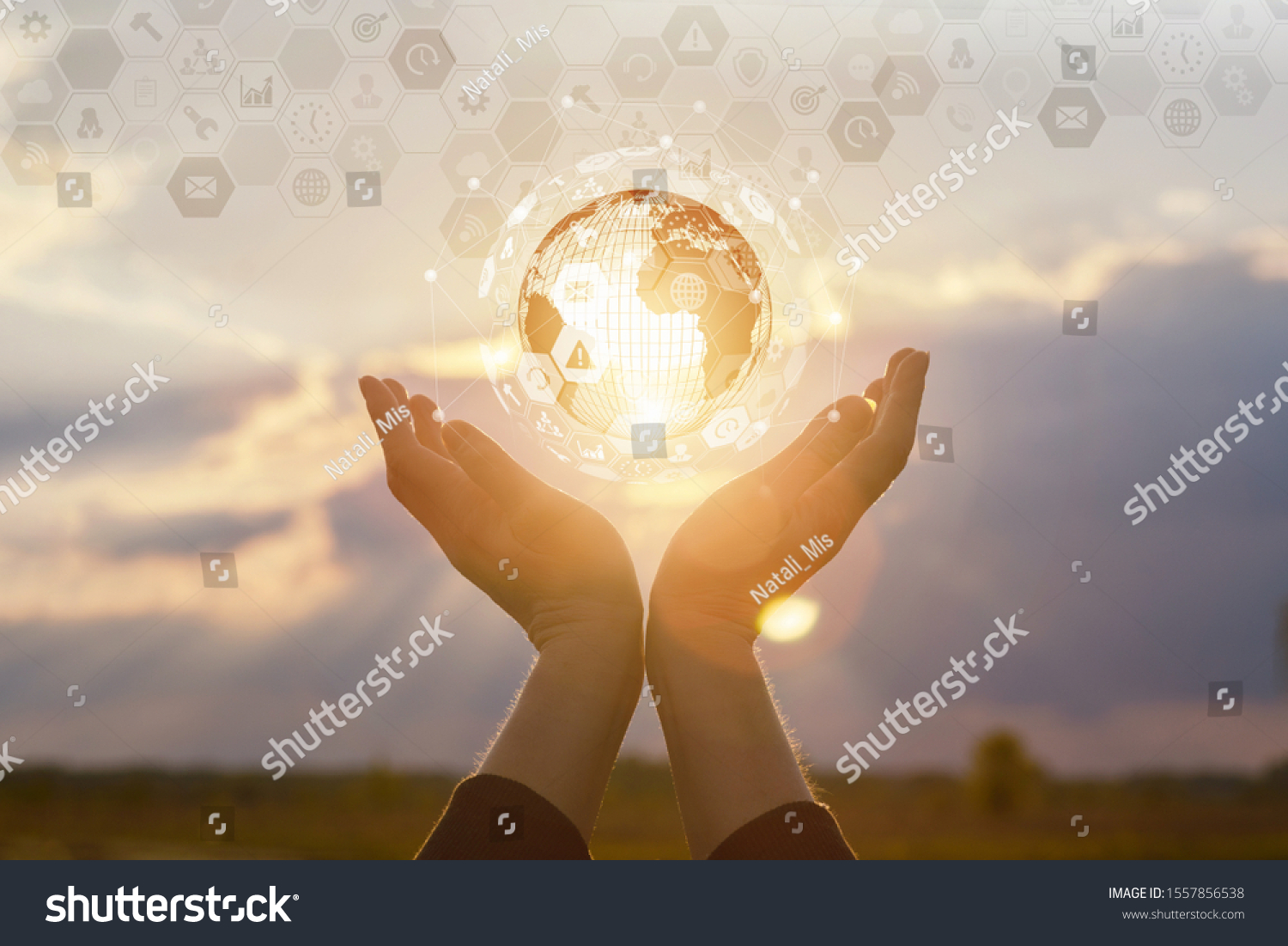 Concept global business and technology. Hand showing business icons and globe at sunset. #1557856538