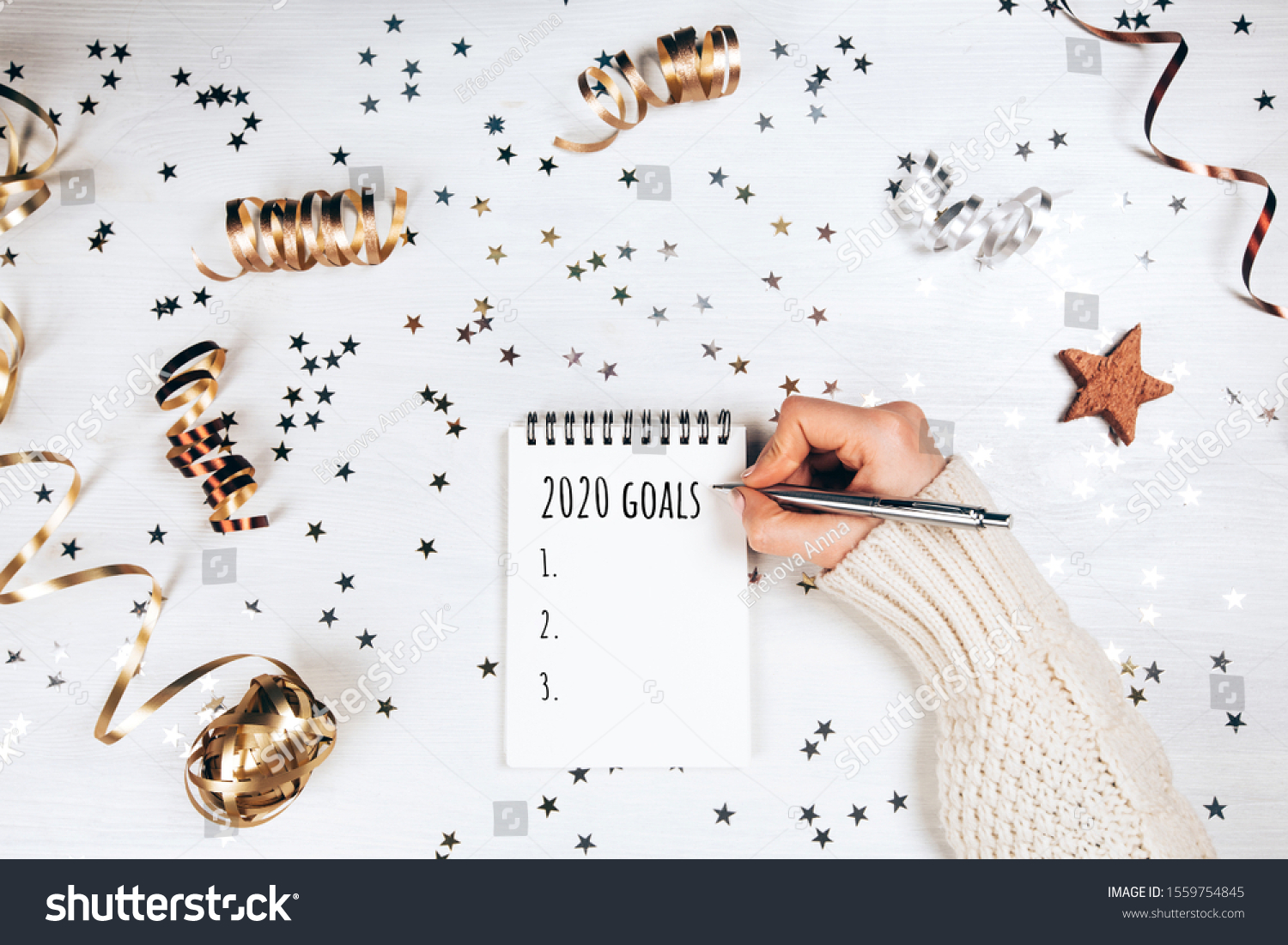 Holiday decorations and notebook with 2020 goals on white table, flat lay style. Christmas planning concept. #1559754845